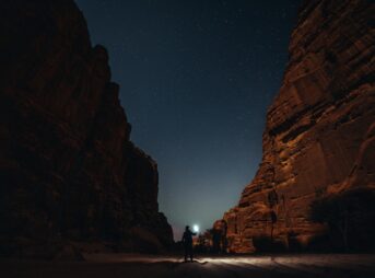 a person standing in the middle of a canyon at night