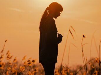 Silhouette of a woman against the setting sun.