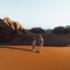 a man and a woman walking in the desert