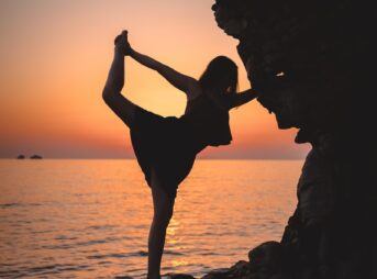 a woman standing on a rock next to the ocean