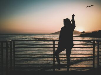 silhouette of woman standing near the fence