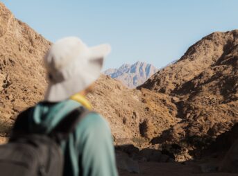 a person with a backpack looking at mountains