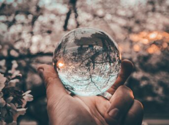 person holding round glass ball