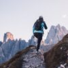 a woman hiking up a rocky trail in the mountains