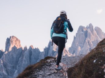 a woman hiking up a rocky trail in the mountains