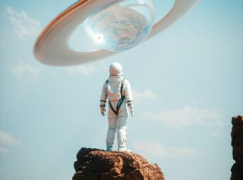 a man in a space suit standing on top of a rock